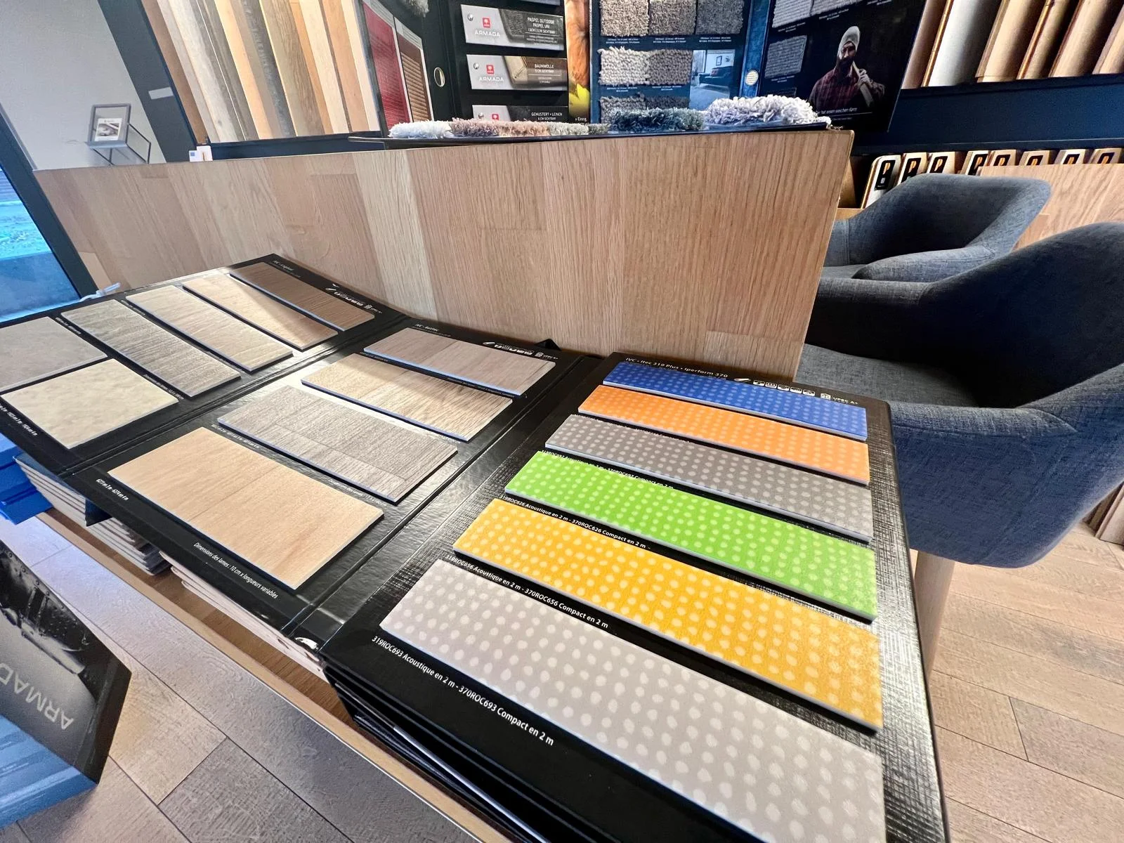 Échantillons de revêtements aux couleurs vives et décors bois présentés sur une table