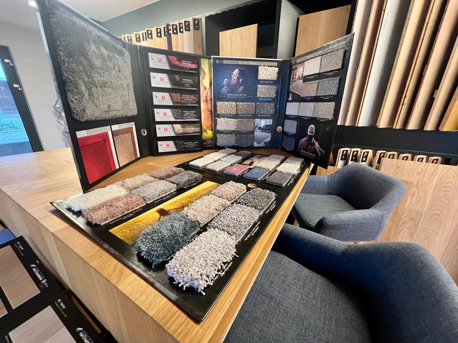 Table de présentation avec échantillons de moquette, décors bois et fauteuils de conseil